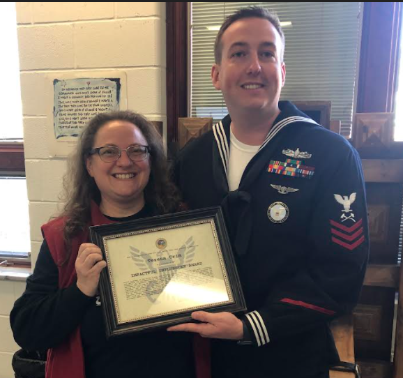 Picture of Mrs. Crim and former student Mark Carroll, Petty Officer 1st Class in the United States Navy, as he presents her with the award